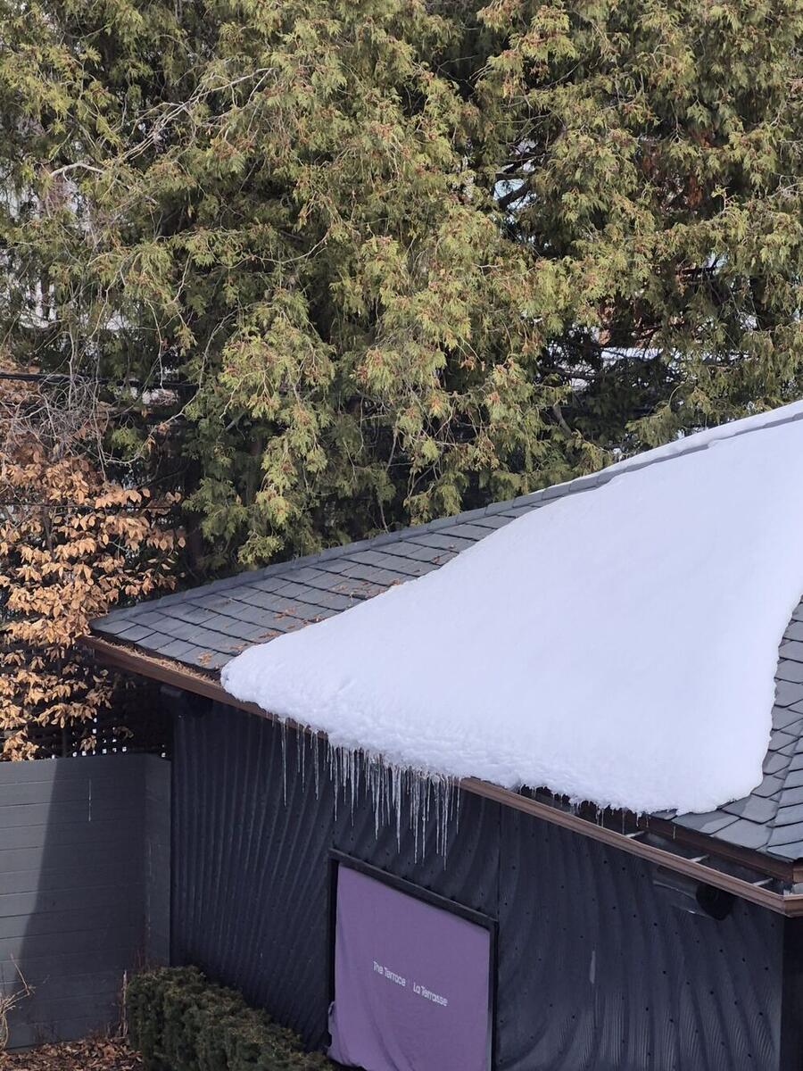 Icicles hanging from a gutter under heavy snow
